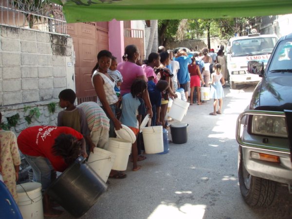 haiti-relief Haitians stand in line to collect water